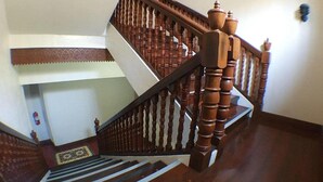 Eine Holztreppe mit Handlauf und einem gemusterten Teppich.