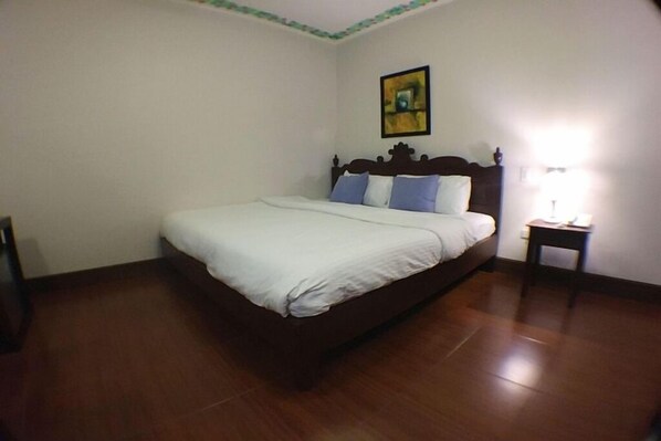 Un dormitorio con una cama individual, una mesita de noche y un cuadro colgado en la pared.
