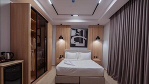 A modern hotel room with a bed, wardrobe, bedside lamps, and a large abstract artwork on the wall. - Tura Residence Sulemania (Riyadh)
