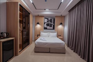 A modern hotel room with a bed, wardrobe, bedside lamps, and a large abstract artwork on the wall. - Tura Residence Sulemania (Riyadh)