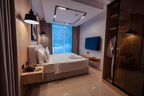 A modern hotel room with a bed, bedside tables, a TV, and a walk-in closet. - Tura Residence Sulemania (Riyadh)