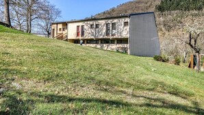 Ein zweistöckiges Gebäude mit flachem Dach, einem Balkon und einem kleinen Anbau.
