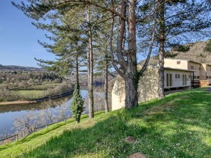 A lakeside property with a building, trees, and a grassy area. - Residence Vacanceole Le Domaine de Confolant (Miremont)