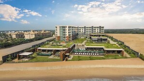 A beachfront hotel with multiple floors, a pool area, and a beach view. - Taj Puri Resort and Spa, Odisha (Brahmagiri)