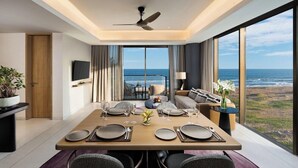 A modern dining area with a view of the ocean, a ceiling fan, and a television on the wall. - Taj Puri Resort and Spa, Odisha (Brahmagiri)