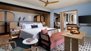 A hotel room with a bed, bedside table, chair, and a small table with fruit. - Taj Puri Resort and Spa, Odisha (Brahmagiri)
