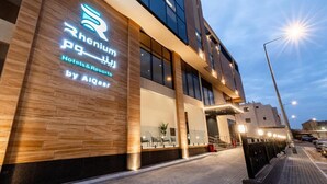 Ein modernes Hotelgebäude mit auffälligem Logo und Beschilderung, das es als Betrieb von Rhenium Hotels & Resorts kennzeichnet.