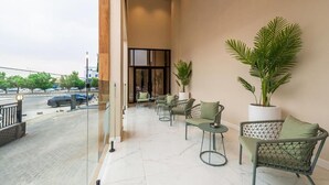 Eine Hotelhalle mit Glastrennwand, einer Sitzecke und Blick auf die Straße.