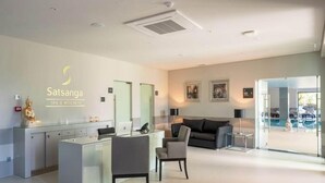 Un moderno centro de spa y bienestar con mostrador de recepción, zona de estar y vistas a una piscina exterior.