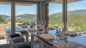 Comedor con una mesa lista para una comida, amplias ventanas que ofrecen vistas al campo.