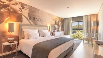 Habitación de hotel moderna con una cama grande, un escritorio y vistas al exterior.