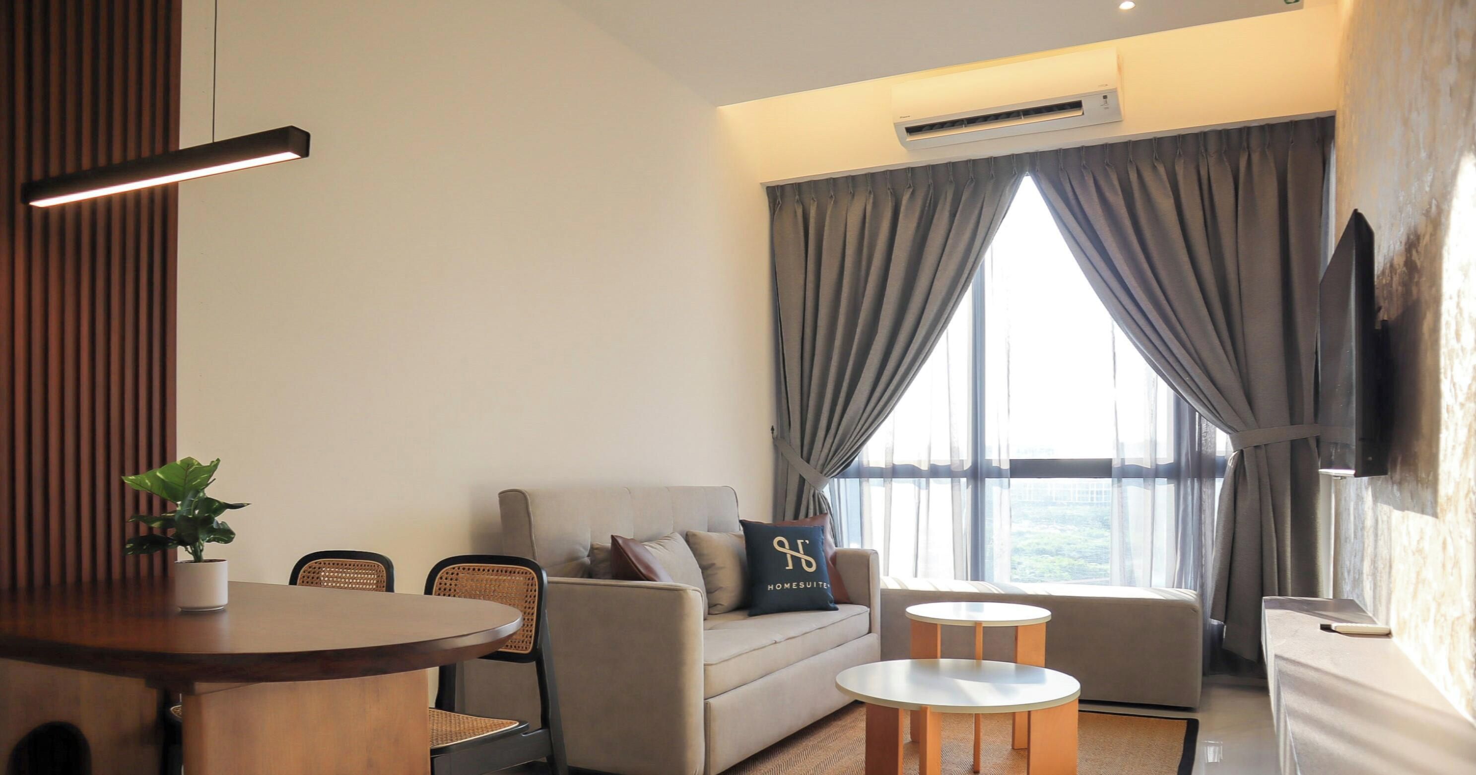 A modern living room with a sofa, two round tables, a TV, and a large window with curtains.