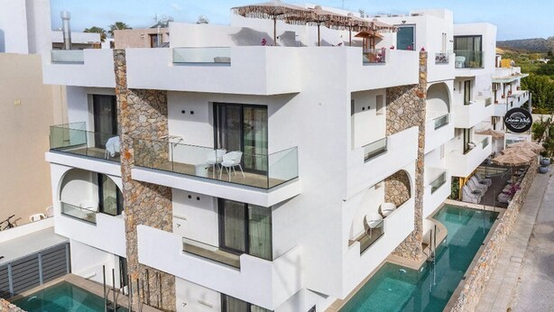 A modern multi-story hotel with balconies, a swimming pool, and a view of the surrounding landscape. - Cabana White Boutique Hotel & Suites (Kos)