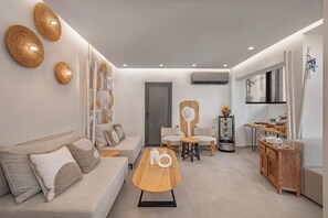 Un saló modern amb sofà, taula de centre i zona de dinar amb un aparador.