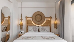 A hotel room with a large bed, two bedside tables, a round mirror, and a headboard with a circular design. - Cabana White Boutique Hotel & Suites (Kos)