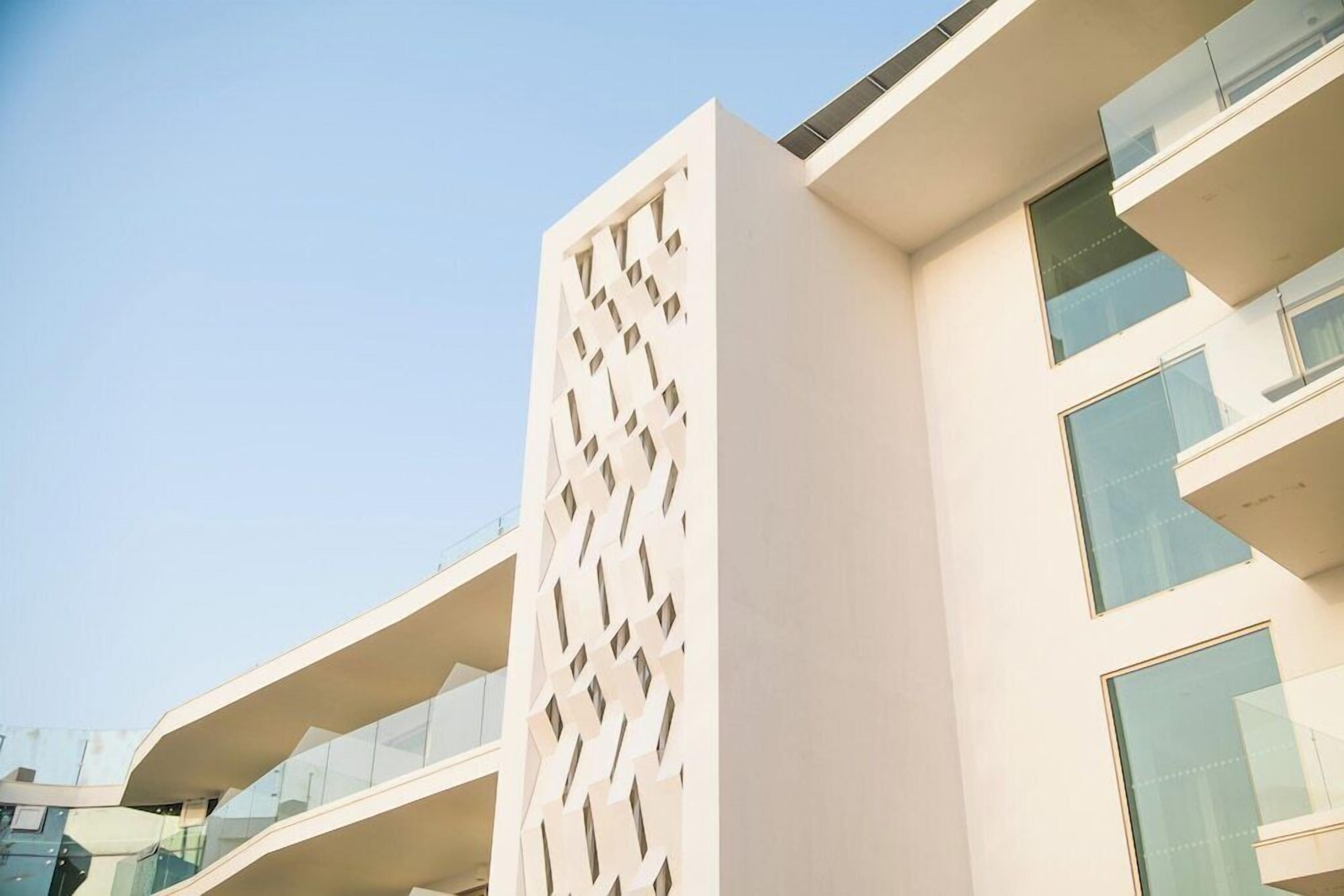 A modern building with a unique geometric facade and balconies.