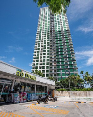 A high-rise building with a commercial establishment at its base. - Dusit Grand Condo View by GV (Banglamung)