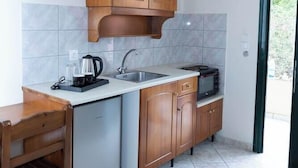 Uma cozinha compacta com armários de madeira, lava-louças embutida, micro-ondas e cafeteira.