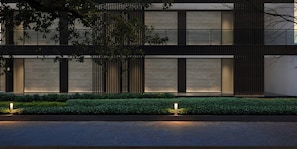A modern building with a flat roof, large windows, and a well-maintained hedge in front. - Hilton Garden Inn Guilin Yangshuo (Guilin)