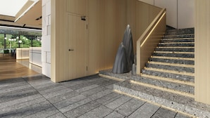 Ein modernes Interieur mit einer Holztreppe, einem Empfangsbereich und Blick ins Grüne.