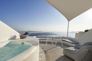 Un espacio al aire libre iluminado por el sol con piscina, sillones de descanso y vistas al mar.