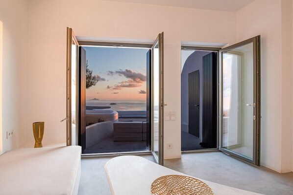 Un dormitorio con un ventanal grande, una cama y vistas a la playa.