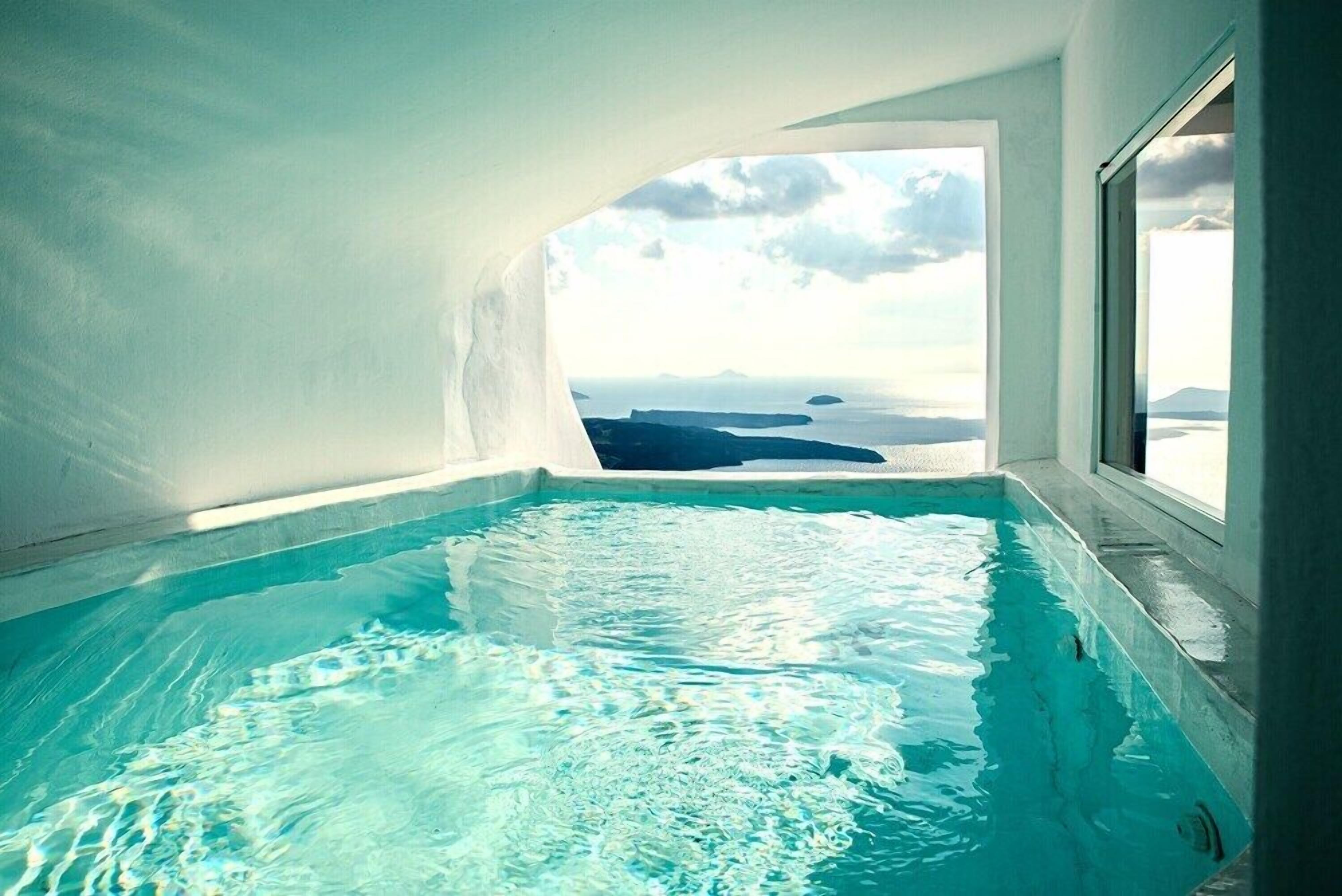 A hot tub with a view of a landscape through a window.