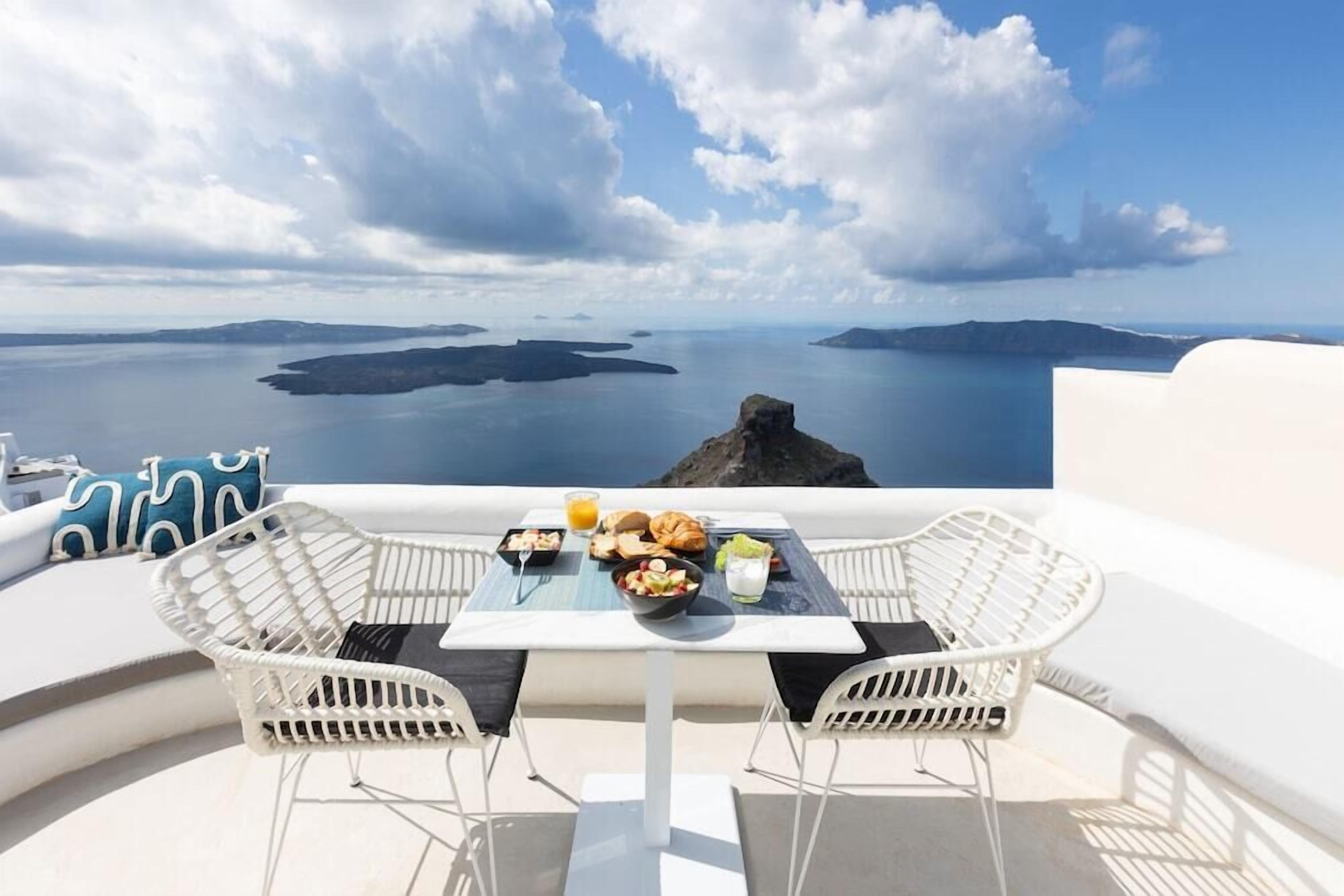 A table with breakfast items and a view of the sea.
