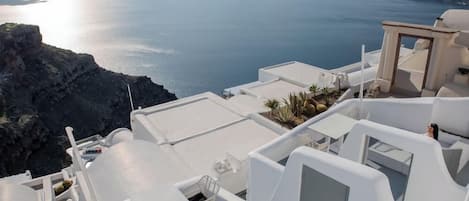A white-roofed building with a view of the sea and islands.