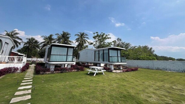 A modern vacation home with a paved pathway leading to a picnic table. - Saga Village Hotel and Resort Bintan (Bintan)
