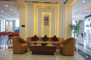 A modern lobby with a sofa set, a coffee table, and a wall-mounted artwork. - Al Mada Arabia Hotel (Jizan)