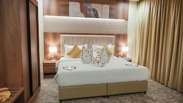 A hotel room with a large bed, two bedside tables, a headboard, and a painting on the wall.