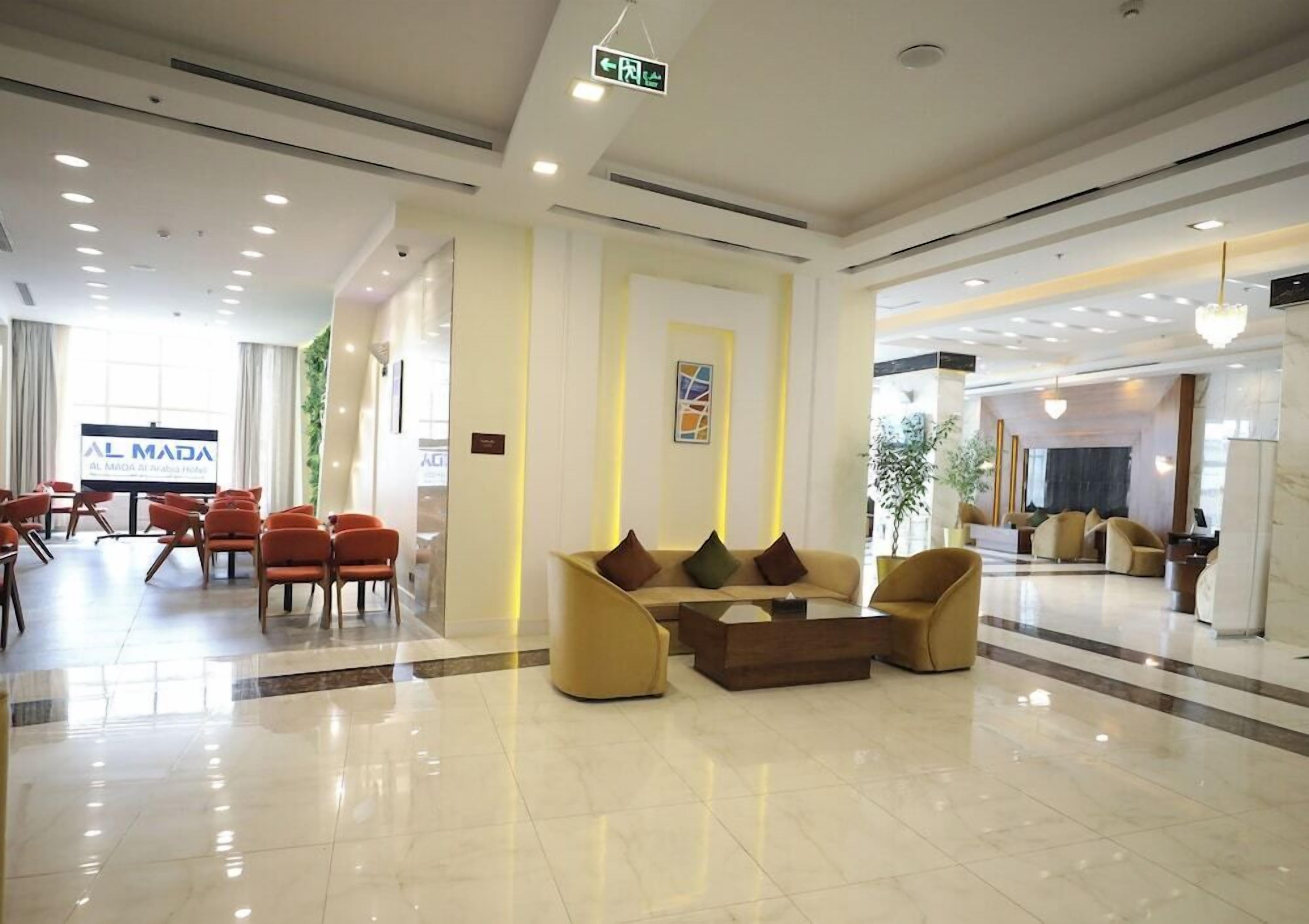 A hotel lobby with a reception desk, seating area, and a large window.