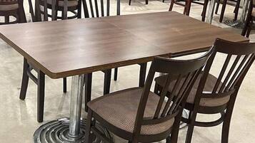 Uma área de refeições com uma mesa retangular e quatro cadeiras.