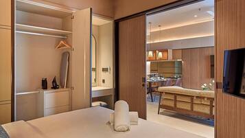 A hotel room with a bed, a wardrobe, a mirror, and a view into a dining area.