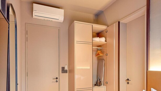 A hotel room with a bed, a wardrobe, and an air conditioning unit. - Antara Genting Highlands by Sleeping Lion (Genting Highlands)