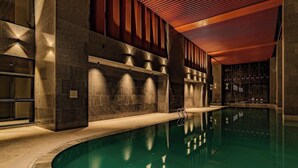 A swimming pool with a curved edge, surrounded by stone walls and a wooden ceiling. - Antara Genting Highlands by Sleeping Lion (Genting Highlands)