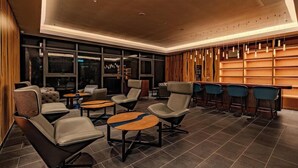 A modern lounge area with leather sofas, round tables, and bar seating. - Antara Genting Highlands by Sleeping Lion (Genting Highlands)
