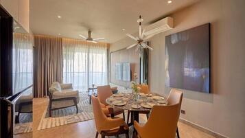 A modern dining area with a round table, chairs, and a ceiling fan.