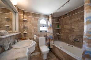 Un baño con bañera, inodoro y lavabo.