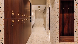 A corridor with wooden lockers, a patterned wall, and a door. - Altis Porto (Porto)