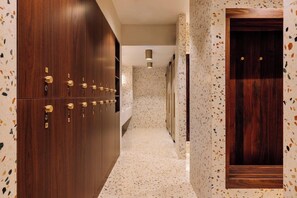 A corridor with wooden lockers, a patterned wall, and a door. - Altis Porto (Porto)