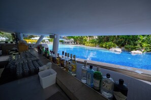 Eine Bar mit Blick auf den Pool, präsentiert mit verschiedenen Flaschen und Gläsern.