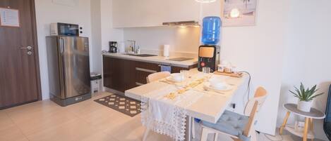 A modern kitchen with a refrigerator, microwave, and coffee maker.