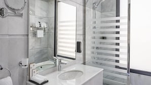 A modern bathroom with a large mirror, a sink, and a glass-enclosed shower. - OYO 687 Sunday Jeddah Hotel (Jeddah)