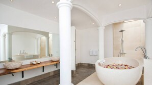 Un baño moderno con una bañera independiente grande, un lavamanos independiente y una ducha.