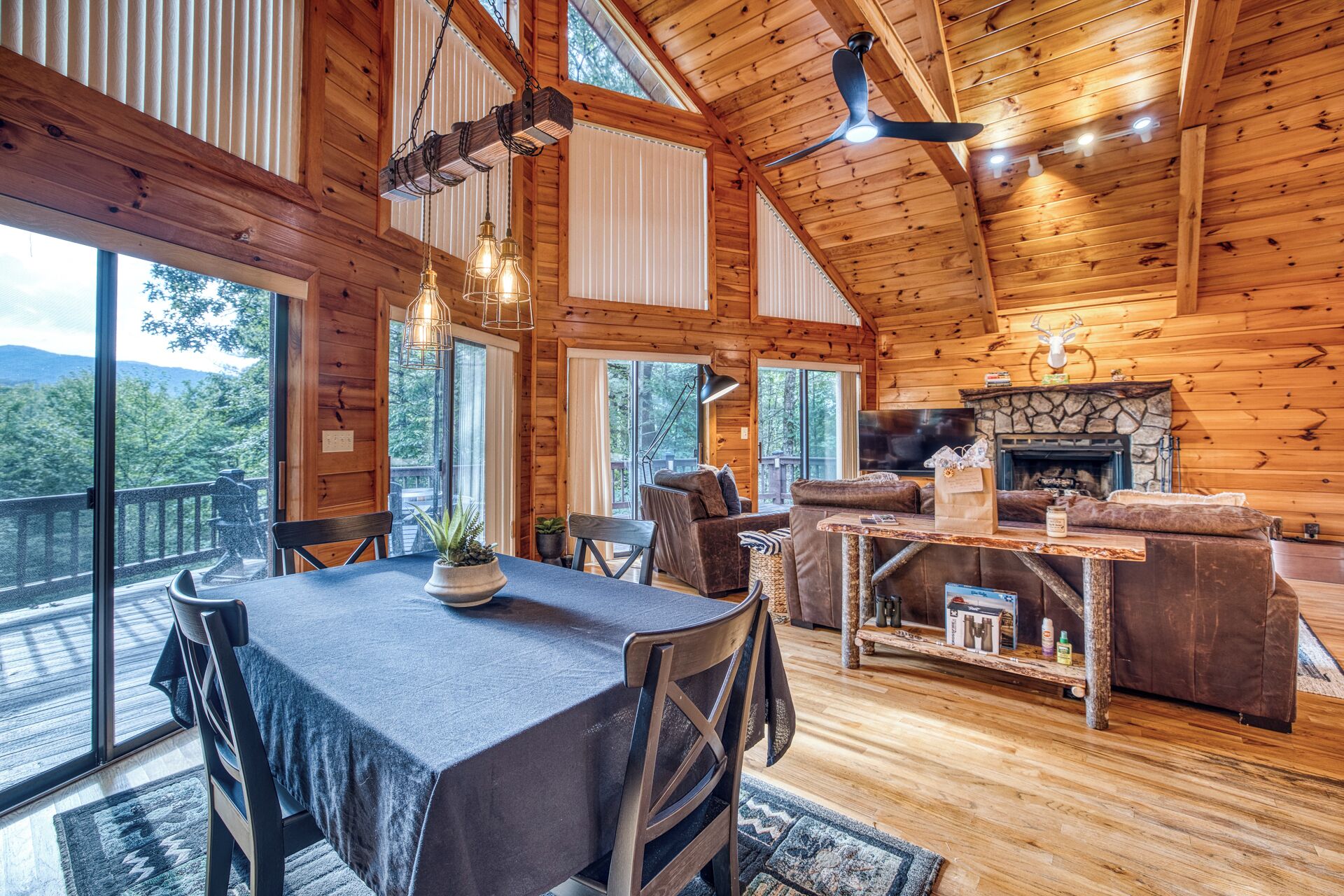 A spacious cabin interior with a dining area, seating, and a fireplace.