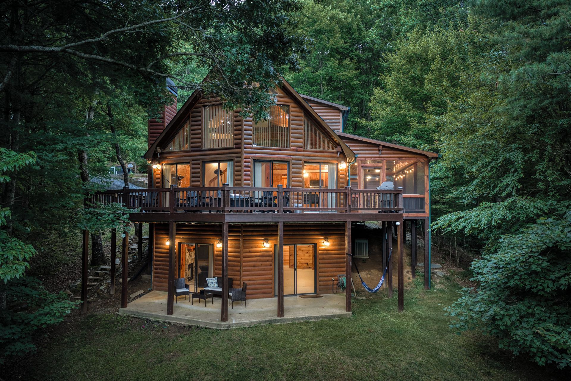 A log cabin with a balcony and outdoor seating area.