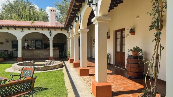 A courtyard with a fountain, seating, and potted plants. - Iraola Hotel Boutique (Salta)