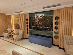 A lobby with a reception desk, seating area, and a large window.
